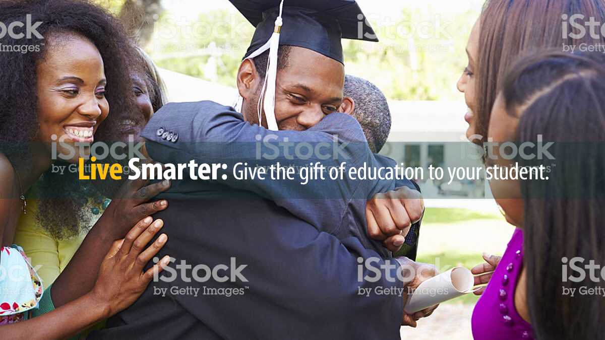 Graduating student hugs his family after graduation, after a Parent Loan helped pay for college